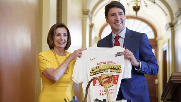 Canadian PM Justin Trudeau holds up a Toronto Raptors shirt presented to House speaker Nancy Pelosi