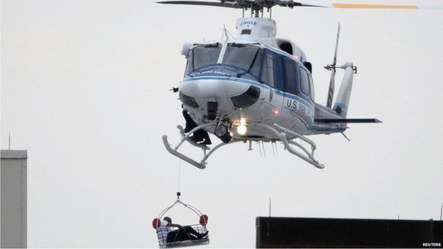 A helicopter rescues an apparent victim of a multiple shooting at the Washington Navy Yard, 16 Sept