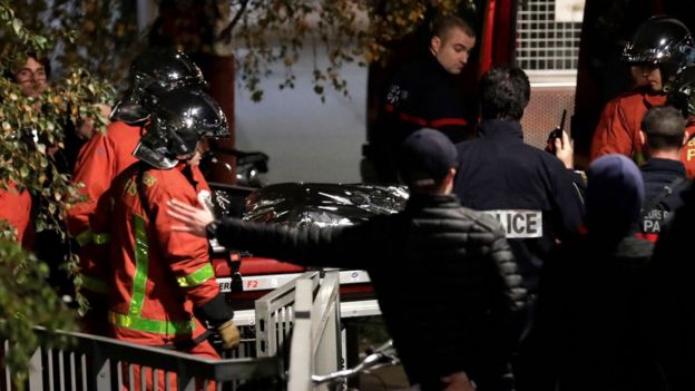Police officials and rescue personnel transport the body of a tiger which had escaped from a circus into a vehicle in Paris on November 24, 2017,