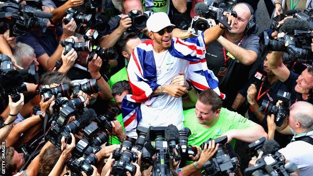 Lewis Hamilton is surrounded by photographers
