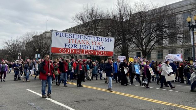 Marchers hold a sign saying president Trump, thank you for pro-life, god bless you