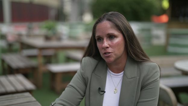 Gillian Fletcher in smart olive coloured blazer sitting at outside tables