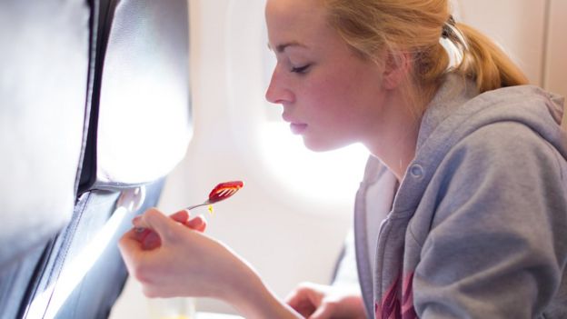 Una persona comiendo en un avión