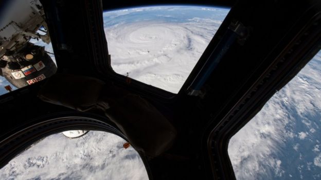 This NASA image from August 25, 2017, taken by NASA astronaut Jack Fischer shows Hurricane Harvey (top) from the cupola module aboard the International Space Station.