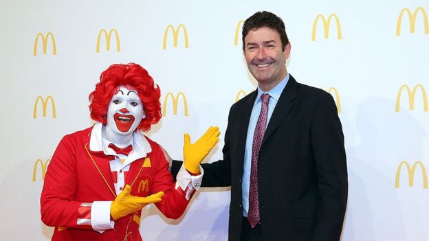 O palhaço que representa o McDonald's sorri e posa ao lado do CEO da empresa, Steve Easterbrook