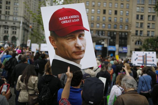Un cartel donde se ve a Vladimir Putin con una gorra que dice: 