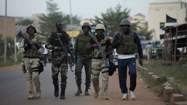 Malian soldiers walk in front of the Radisson hotel in Bamako (20 November 2015)