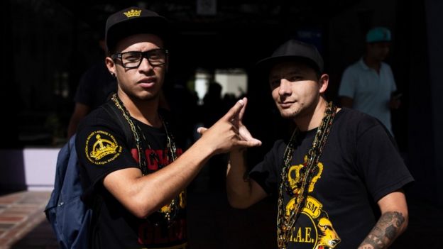 Dois membros do grupo Latin Kings trocam saudação