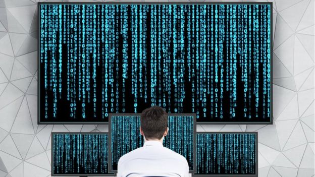 Man looking at matrix on computers