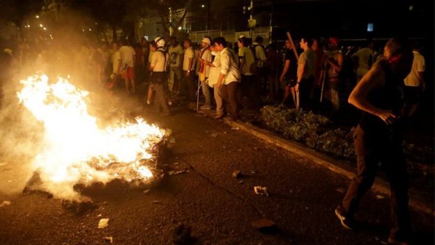 Manifestantes en Guayaquil encienden fuego en una calle.