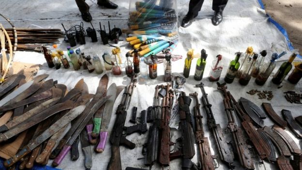 Rifles, machetes and petrol bombs on display.