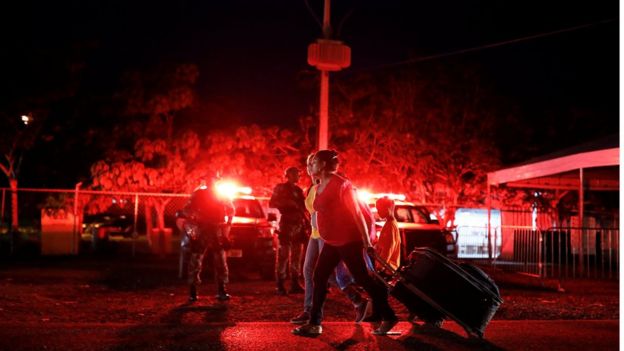 Militares fazem patrulha enquanto venezuelanas caminham em direção a Santa Elena para dormir depois de terem passado pela fronteira em Pacaraima