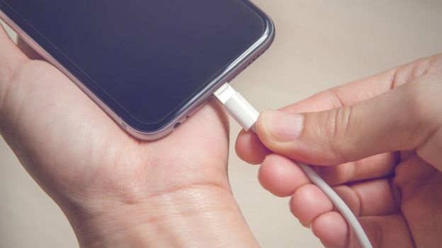 Cell phone connecting to a charger.