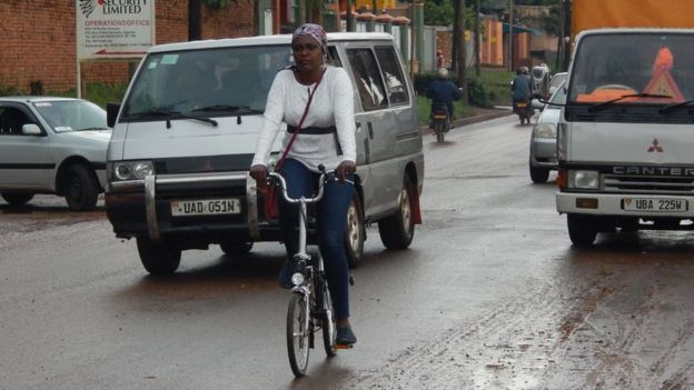 Amanda Ngabirano monta su bicicleta en una calle con tráfico.