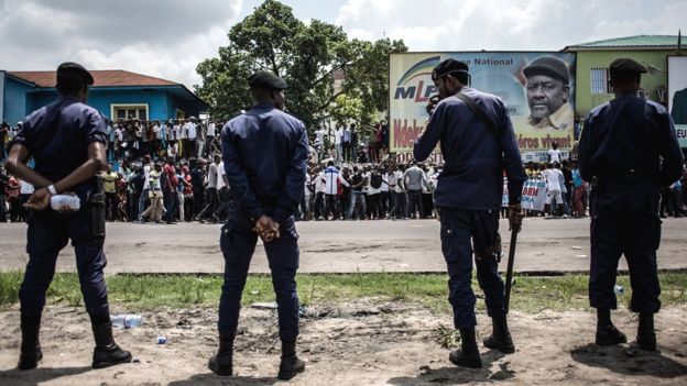 Police stand in front of supporters of Democratic Republic of Congo opposition leader and presidential candidate Martin Fayulu as they take part in a protest to contest presidential election results in Kinshasa on 11 January 2019