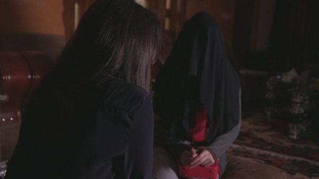 Nawal al-Maghafi berbincang dengan seorang gadis yang identitasnya disembunyikan dengan mengenakan sebuah cadar hitam