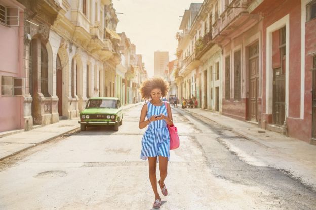 A young Cuban woman walking down a street in Havana