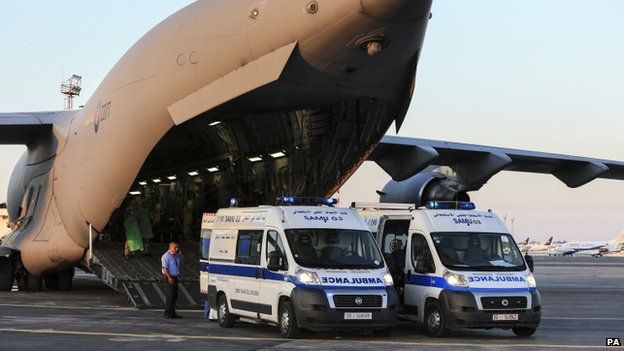Two Tunisian ambulances parked at the back of an RAF C17 aircraft