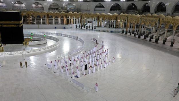 In this file photo taken on April 27, 2020, worshippers perform Isha prayer while keeping distance between them next to the Kaaba in Mecca's Grand Mosque