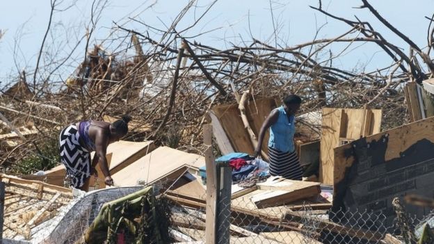 Two women look through the remains of a house destroyed by Hurricane Dorian in Great Abaco Island, Bahamas, 5 September
