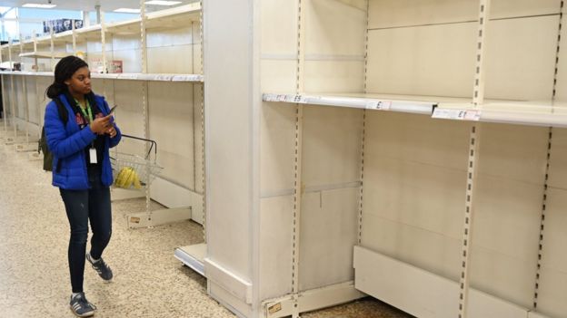 A customer looks at empty shelves in the toilet roll section of a store in north London, Britain, 12 March 2020. The number of UK coronavirus cases continues to rise while ten people have now died due to Coronavirus outbreak.