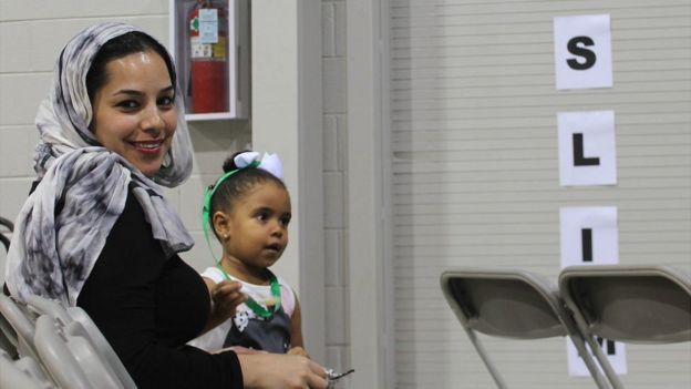 Una mujer musulmana mira a la cámara junto a una niña que está a su lado