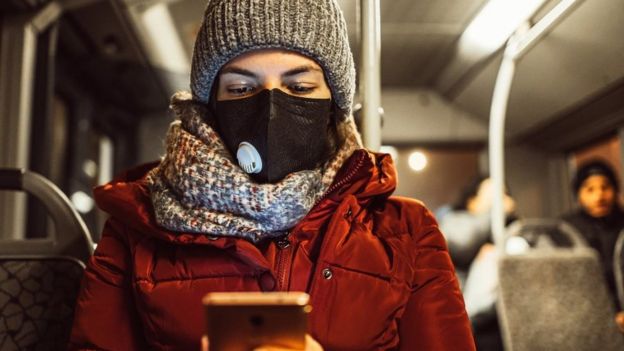 Woman wearing face mask on bus