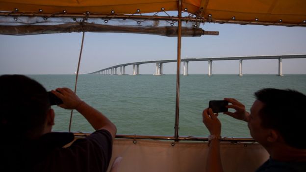Penumpang feri mengambil foto jembatan