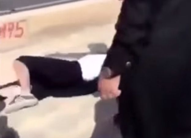 Frame from video of woman in Saudi Arabia on the ground