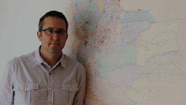 Natalio Cosoy junto al mapa que hay en la oficina de la corresponsalía de BBC Mundo en Colombia.