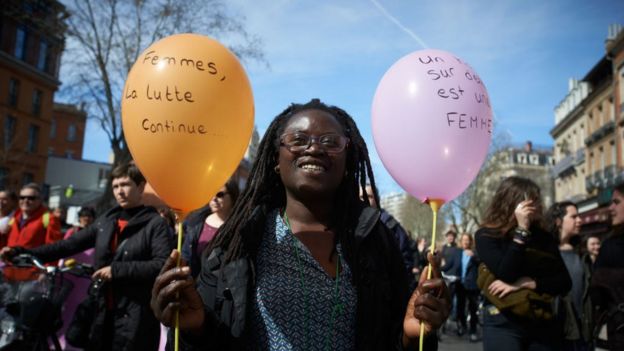 Una mujer con un globo en el que dice "Mujeres, la lucha continúa".