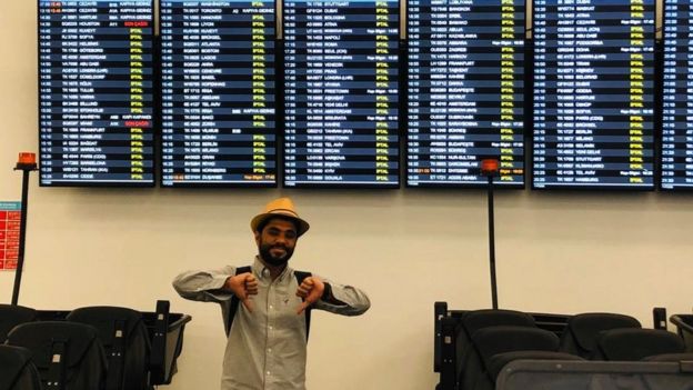 Khalid poses in front of departure boards