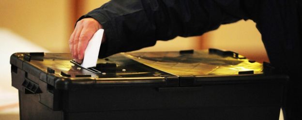 Man placing vote in ballot box