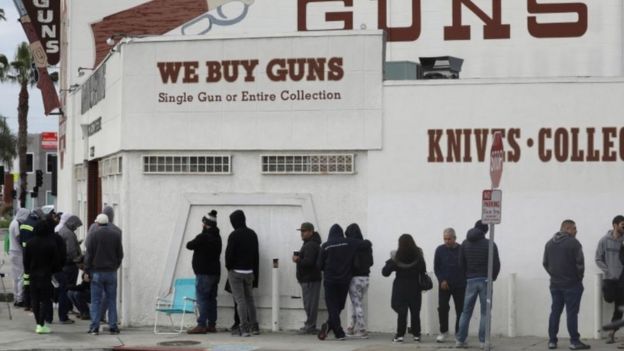 People wait in line outside to buy supplies at a gun store in Culver City, California,