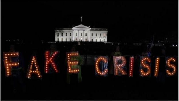 Başkan Trump'ın konuşmasının ardından göstericiler Beyaz Saray önünde 'Sahte Kriz' yazdı.