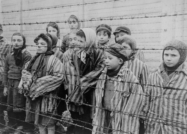 Crianças sobreviventes de Auschwitz, resgatadas pelo Exército da União Soviética, algumas delas identificadas pelo Museu do Holocausto, EUA: 'Tomasz Szwarz; Alicja Gruenbaum; Solomon Rozalin; Gita Sztrauss; Wiera Sadler; Marta Wiess; Boro Eksztein; Josef Rozenwaser; Rafael Szlezinger; Gabriel Nejman; Gugiel Appelbaum; Mark Berkowitz (um gêmeo); Pesa Balter; Rut Muszkies (depois Webber); Miriam Friedman; e as gêmeas Miriam Mozes e Eva Mozes, usando gorros tricotados
