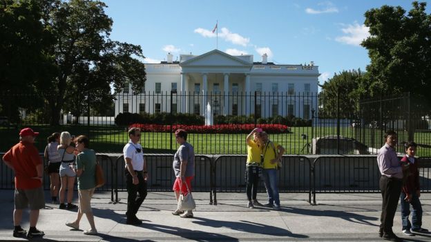 Tourists mill outside the north fence of the White House