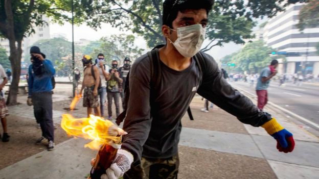 Un manifestante con un cóctel molotov