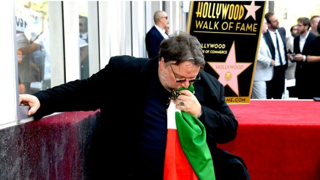 Guillermo del Toro besando la bandera de México en el Paseo de la Fama.