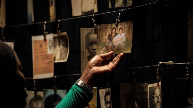 This file photo taken on April 29, 2018 shows a visitor looking at victims" portraits at the Kigali Genocide Memorial in Kigali, Rwanda