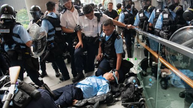 An injured Police officer lies on the floor during a protest against a proposed extradition law on June 12, 2019 in Hong Kong