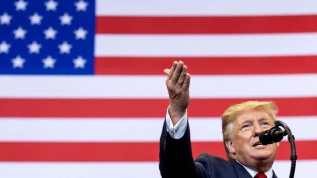 donald trump in front of a flag
