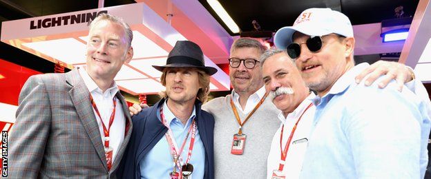 Actors Owen Wilson and Woody Harrelson pose for a photo with Sean Bratches, Managing Director (Commercial Operations) of the Formula One Group, Chase Carey, CEO and Executive Chairman of the Formula One Group and Ross Brawn, Managing Director (Sporting) of the Formula One Group at the Cars movie inspired garage before the Formula One Grand Prix of Great Britain at Silverstone on July 16, 2017 in Northampton