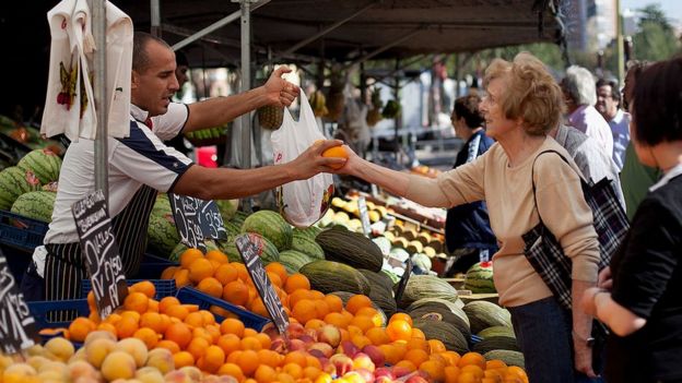 Mujer comprando naranjas
