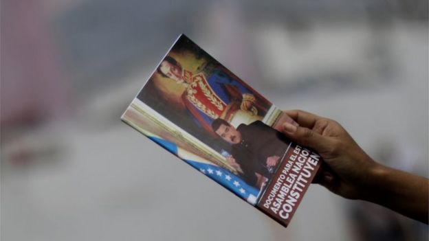 A supporter of Venezuelan President Nicolas Maduro shows a document on the National Constituent Assembly during a rally in Caracas, Venezuela, July 24, 2017.