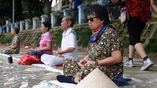 Một nhóm người dân khác tập luyện Pháp Luân Công bên bờ hồ ở Hà Nội