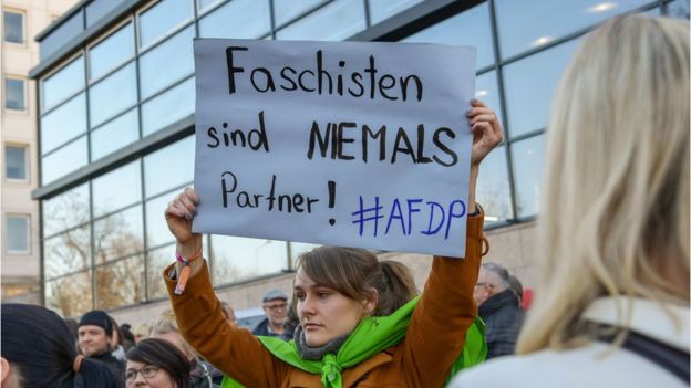 People demonstrate outside Thuringia"s State parliament building with a banner reading "Fascists are never partners !"