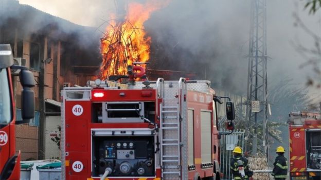 Firefighters attend a blaze at a factory in Sderot, Israel, which was hit by a rocket from Gaza (12/11/19)