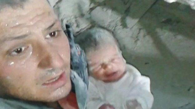 Khaled Harrah with a 10-day old baby rescued from rubble