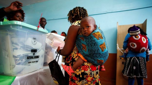 Women carrying babies cast their vote in Gatundu in Kiambu county, Kenya, 8 August